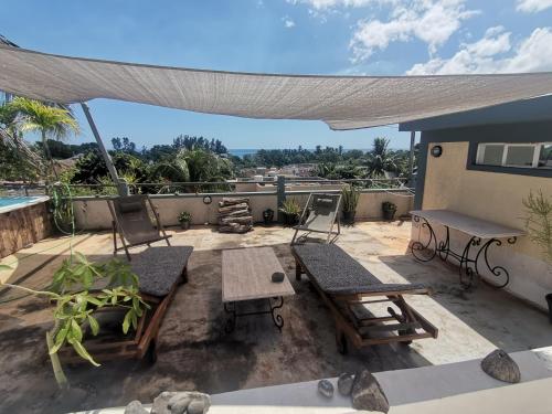 a patio with chairs and a table on a roof at Apartment 3bedrooms 2bathrooms rooftop jacuzzi in Pointe aux Sable