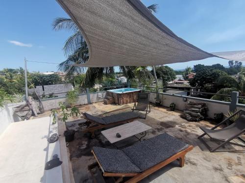 a patio with a table and chairs on a roof at Apartment 3bedrooms 2bathrooms rooftop jacuzzi in Pointe aux Sable