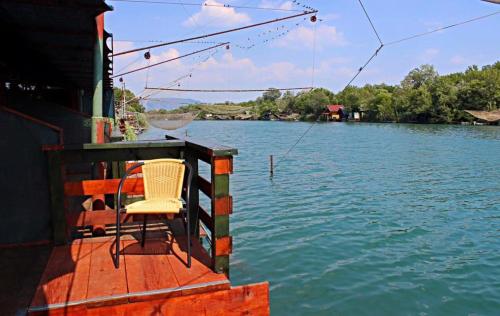 una silla sentada al final de un barco en el agua en Holiday Home Bojanka, en Ulcinj