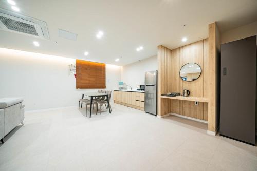 a kitchen with a table and a refrigerator at Mokpo Brown Dot Hotel Namak in Mokpo