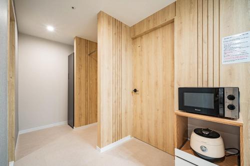 a room with a tv and a wall with a door at Mokpo Brown Dot Hotel Namak in Mokpo