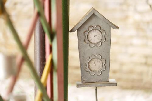 a metal birdhouse with a clock in it at Lara free parking Skadarlija in Belgrade
