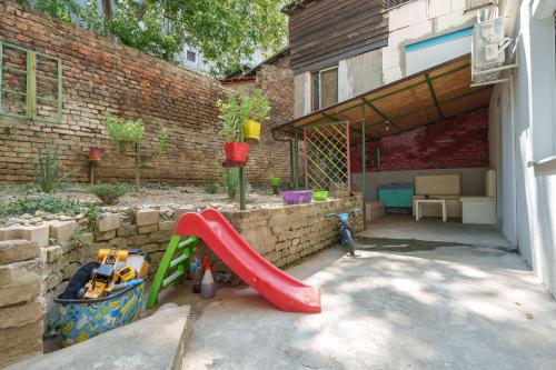 a playground with a red slide in a backyard at Lara free parking Skadarlija in Belgrade