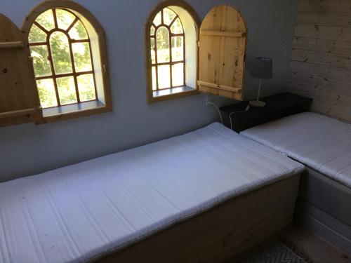 two beds in a room with two windows at Lækkert feriehus ved Lønstrup in Hjørring