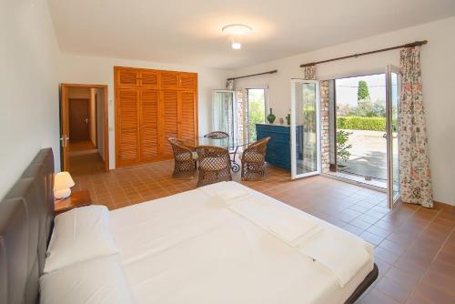 ein Schlafzimmer mit einem Bett und einem Tisch und Stühlen in der Unterkunft WELCS CASA IMPRESIONANTE 179 PDA con piscina privada in Begur