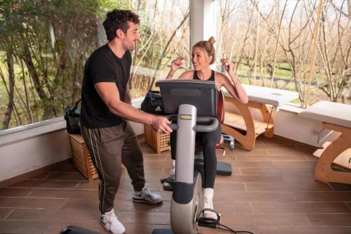 a man and a woman standing next to a exercise machine at Hotel Villa Rizzo Resort and Spa in San Cipriano Picentino