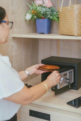 a woman is putting food into a toaster oven at Botan Boutique Hotel in Patong Beach