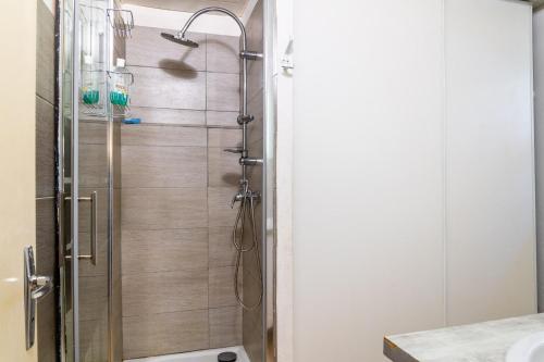 une douche avec une porte vitrée dans une salle de bain dans l'établissement Gites de france 6 pers aux bondons, à Les Bondons