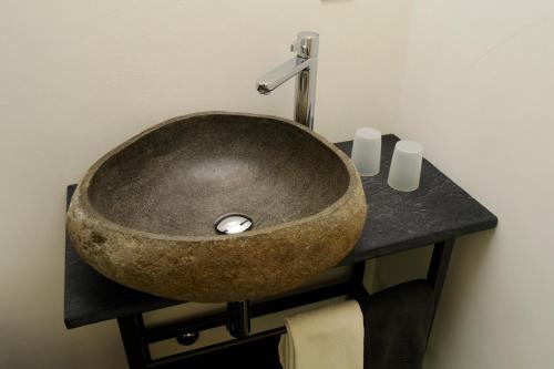 a bathroom with a stone sink on a counter at Casa Martinelli, Boutique-Hotel in Maggia