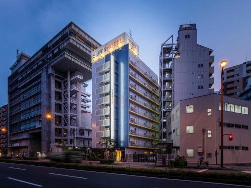 a building with a sign on the side of a street at Super Hotel JR Shin-Osaka Higashiguchi in Osaka