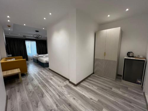 a room with a white wall and a bed and a television at Onyx Pyramids Boutique Hotel in Cairo