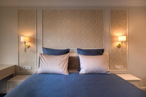 a bedroom with a blue bed with two pillows at Gradiali Wellness and SPA in Palanga