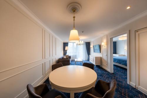 a room with a table and chairs and a bed at Gradiali Wellness and SPA in Palanga