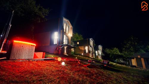 a building at night with red lights on the grass at Blissful Resort - Valea Doftanei in Teşila