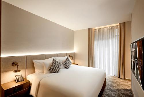 a hotel room with a white bed and a television at REY Hotel Hanoi in Hanoi