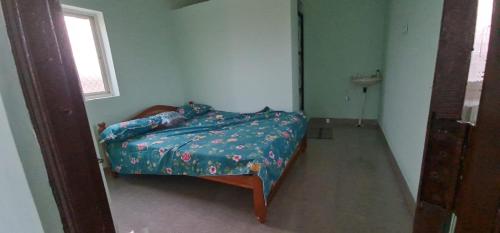 a bedroom with a bed with a blue comforter and a window at Farm House With Swimming pool, Celebration area Below 5000 yadagirigutta Hyderabad in Wasalmari