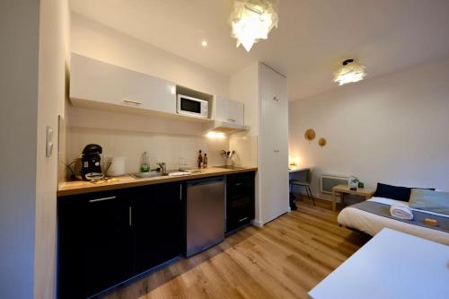 une cuisine et une chambre avec un lit dans une pièce dans l'établissement Rouen centre - chez Cédric, à Rouen