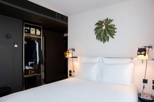 a bedroom with a large bed with white pillows at Mama Shelter Lisboa in Lisbon
