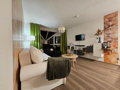 a living room with a white couch and a table at Ferienwohnung mit Weinbergblick in Radebeul