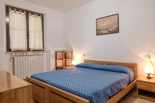 a bedroom with a bed with a blue comforter at Agriturismo Brancalino in Magliano in Toscana