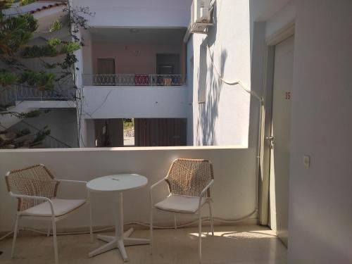 a table and chairs in a room with a balcony at Achilleas Hotel in Parga