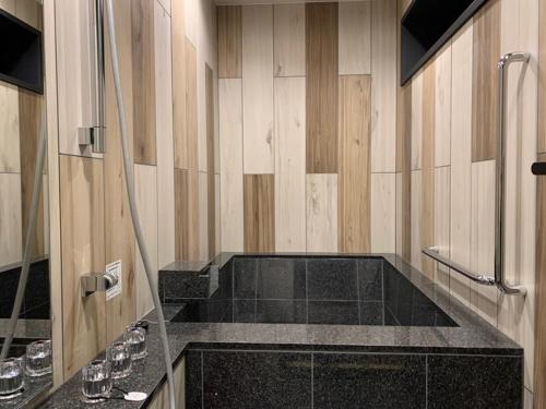 a bathroom with a shower and a black counter top at Yunokura Tsuruya in Makago