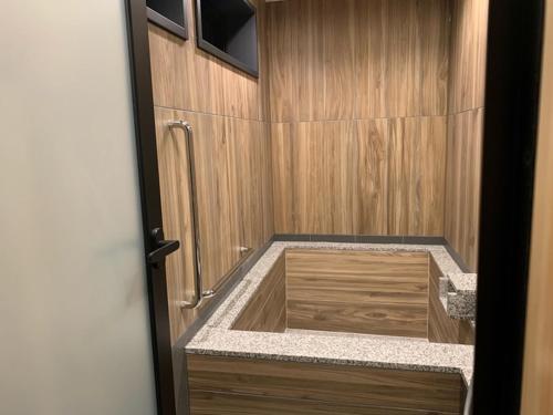 a bathroom with a shower with a wooden counter top at Yunokura Tsuruya in Makago