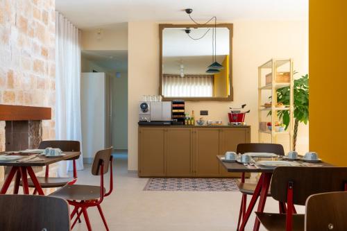 een eetkamer met 2 tafels en een keuken bij B&B Radici d'Olivo in Bisceglie