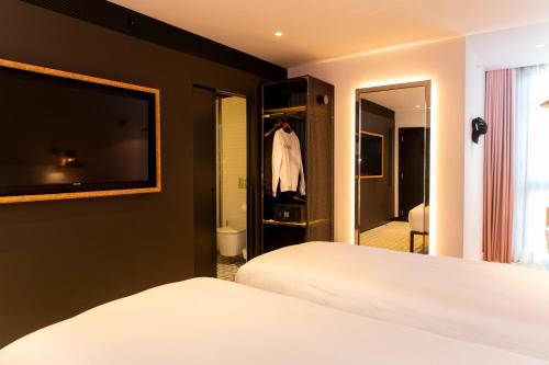 a bedroom with two beds and a large mirror at Mama Shelter Lisboa in Lisbon