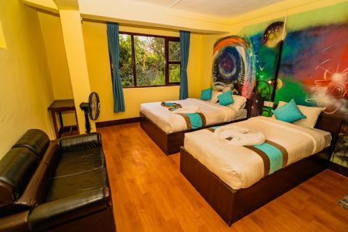 two beds in a room with a painting on the wall at Rest Up Kathmandu Hostel in Kathmandu