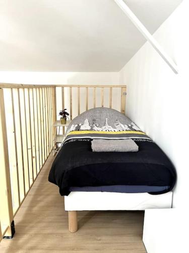 a bedroom with a bed with a black blanket at 735 Cosy studio mezzanine près de Paris et métro in Bagnolet