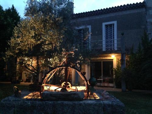 una fuente frente a una casa por la noche en Les Jardins du Rebaut, en Béziers