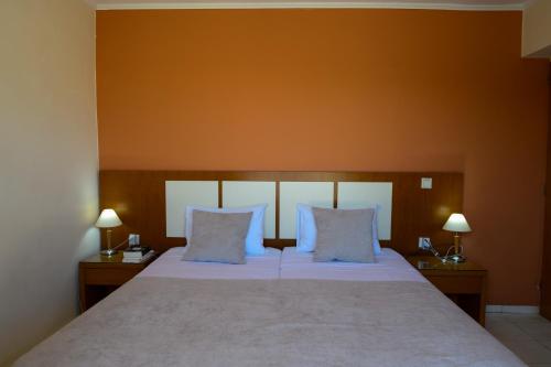 a bedroom with a large bed with two night stands at Esperides Beach Hotel Apartments in Stalos