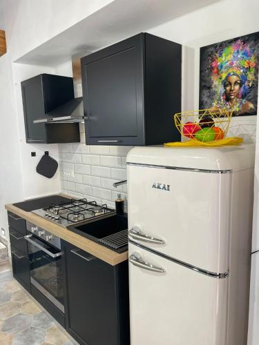 a white refrigerator in a kitchen with a painting on the wall at Hermès Home in Agrigento