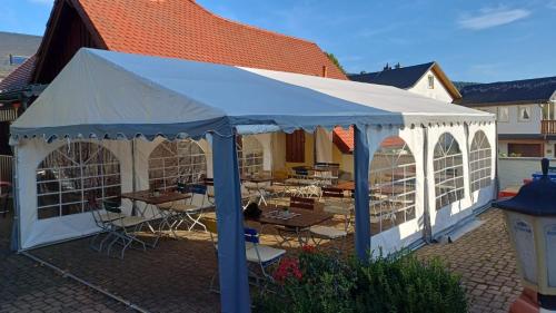 a white tent with tables and chairs in a courtyard at Landhotel Jägerhof in Bischofsgrün
