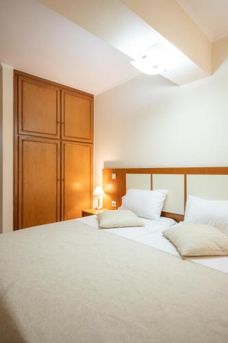a bedroom with two beds and a cabinet at Esperides Beach Hotel Apartments in Stalos