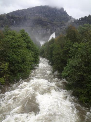 a river with white water and trees on the side at Casa Martinelli, Boutique-Hotel in Maggia