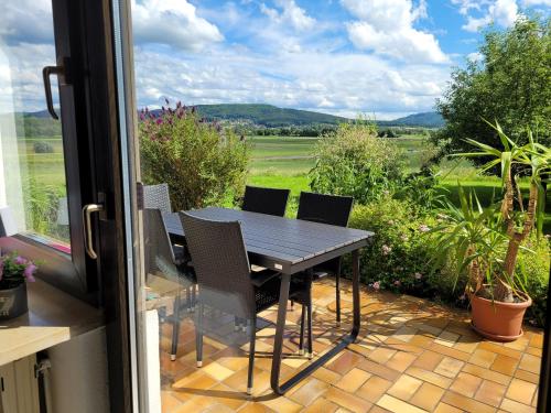 a table and chairs on a patio with a view at Ferienwohnung Berg-Anni in Rüssenbach