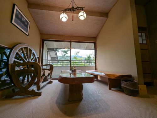 a living room with a table and a wooden wheel at Ryoso Yufuin Yamadaya in Yufuin