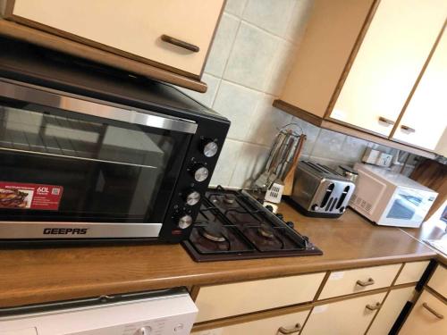 a microwave oven sitting on top of a kitchen counter at London Stockwell Station Apartment in London