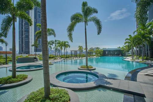 Una gran piscina con palmeras y edificios. en Skyscraper 65 KL Highest Outdoor Bathtub Luxury Lavish Designer Suite Penthouse Lv65, en Kuala Lumpur