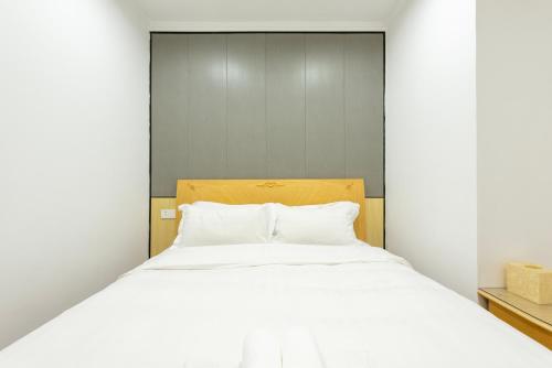 a bedroom with a large bed with white sheets at Qingdao Liuying Jieli Hotel - Qingdao Station Trestle Bridge Branch in Qingdao