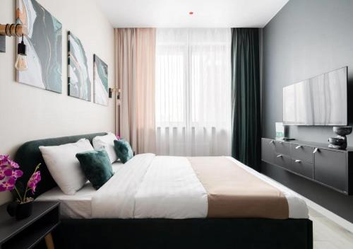 a hotel room with a bed and a television at Modern апарт-отель, напротив Ботанического Сада in Astana