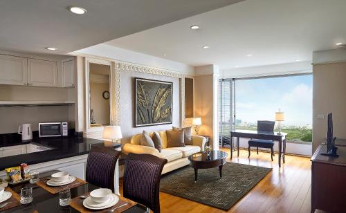 a living room with a couch and a table at Grande Centre Point Hotel Ratchadamri Bangkok in Bangkok