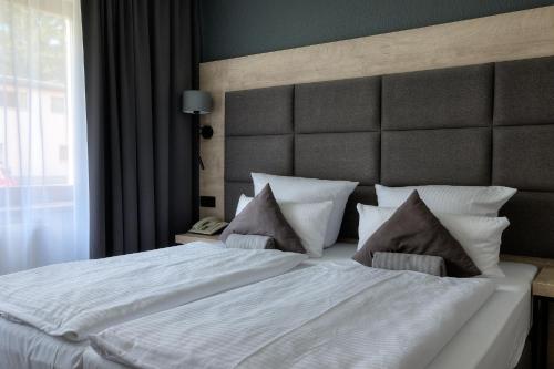 a bedroom with a large white bed with pillows at Waldhotel Wandlitz in Wandlitz