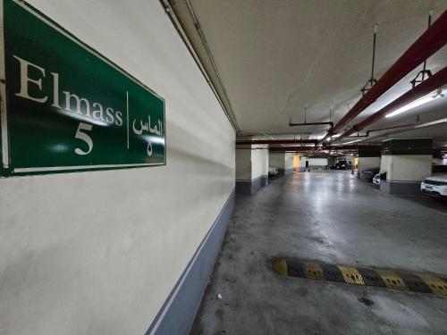 a green sign on a wall in a parking garage at LUXURY HOTEL APARTMENT at GRAND PLAZA SAN STEFANO, PRIME LOCATION with access to MEGA MALL and FOUR SEASONS'S RESTAURANTS in Alexandria