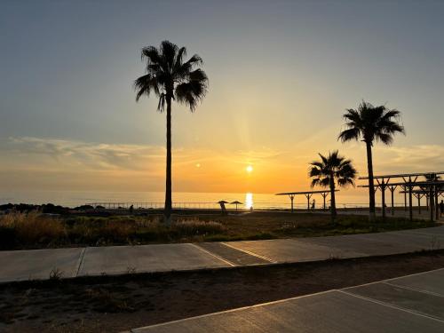 a sunset at the beach with palm trees at Diana HATS 1B, Pool, Paphos Center in Paphos City