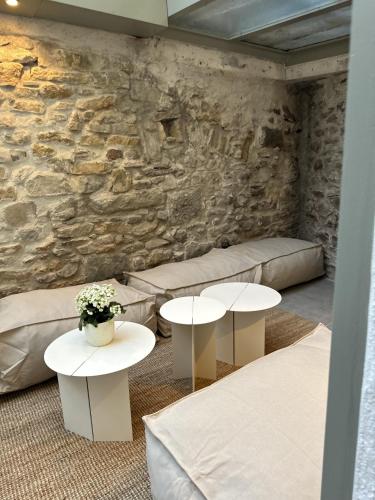 a room with two tables and a stone wall at La Demeure de la Cité by Jean Bacou in Carcassonne