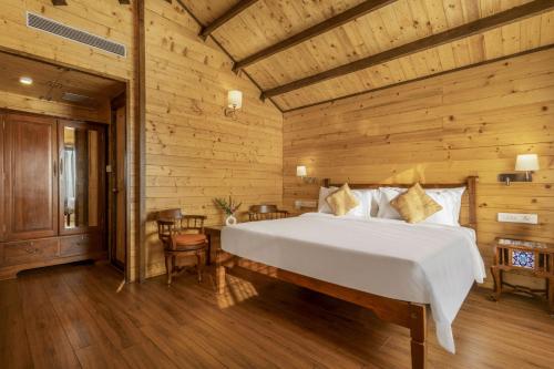 a bedroom with a bed and a wooden wall at Bogmallo Beach Resort in Bogmolo