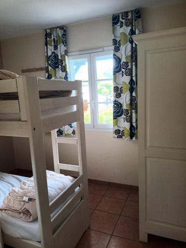 une chambre avec un lit superposé et une fenêtre dans l'établissement Au pied de la Dordogne, à Argentat